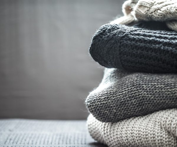 A stack of knitted sweaters ,the concept of warmth and comfort, hobby , background,closeup